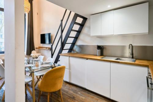 une cuisine et une salle à manger avec une table et un escalier dans l'établissement Bright 3-bedroom 2-bathroom flat., à Lille
