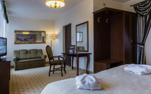 a hotel room with a bed and a desk at Zamek Gniew - Pałac Marysieńki in Gniew