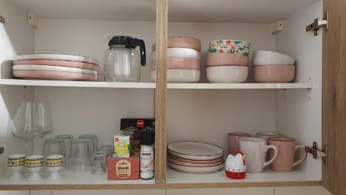 a cupboard filled with dishes and other kitchen items at Ruhige Unterkunft im Erdgeschoss ,Nähe Schloss & UNESCO-Geopark, Waldeisenbahn, Natur und Kultur direkt vor der Tür in Bad Muskau