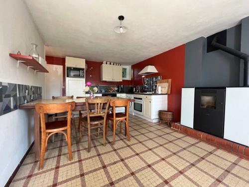 Il comprend une cuisine avec une table et des chaises en bois. dans l'établissement Ma Rober Rit, à Saint-Germain-sur-Ay