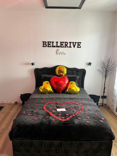 a bed with a black bedspread with a red heart at BelleRive Love Room in Publier