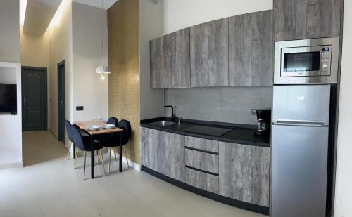 a kitchen with a refrigerator and a table with a microwave at La LIPA in Almáchar