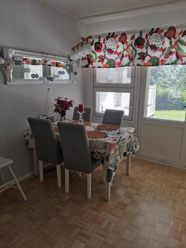 a dining room with a table and chairs and a window at Hirvikoto in Sotkamo
