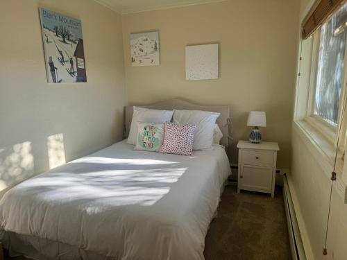 a bedroom with a white bed with a nightstand and a window at Family & Friends Holiday House in Snowmass Village