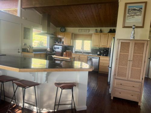 a kitchen with a counter and some stools in it at Family & Friends Holiday House in Snowmass Village