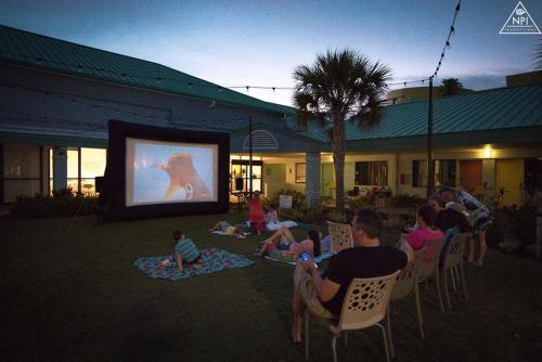 a group of people sitting in chairs watching a movie at Beachside Hotel & Suites Cocoa Beach - Port Canaveral in Cocoa Beach