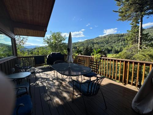 a deck with chairs and a table and an umbrella at Family & Friends Holiday House in Snowmass Village
