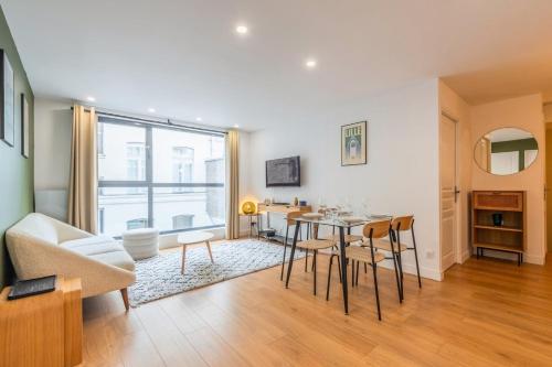 un salon avec une table et un canapé dans l'établissement Appart 2 chambres proche Vieux Lille, avec parking, à Lille