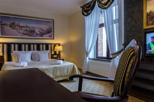 a hotel room with a bed and a tv at Zamek Gniew - Pałac Marysieńki in Gniew