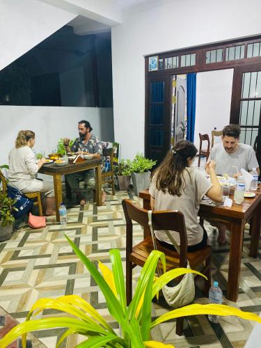 a group of people sitting at tables in a restaurant at Mario Family Villa and Restaurant in Negombo