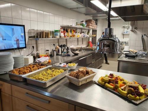 a kitchen with several trays of food on a counter at Penzion a Restaurace u Sousedů in Strážný