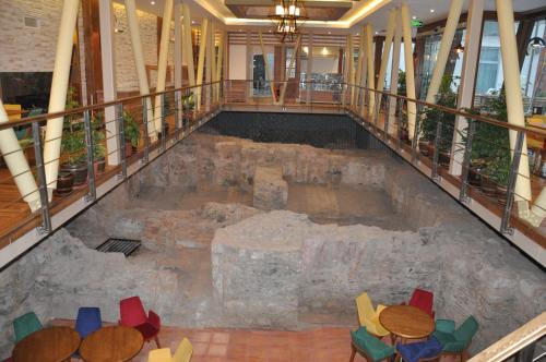an indoor pool with chairs and tables in a building at Giritligil Hotel in Manisa