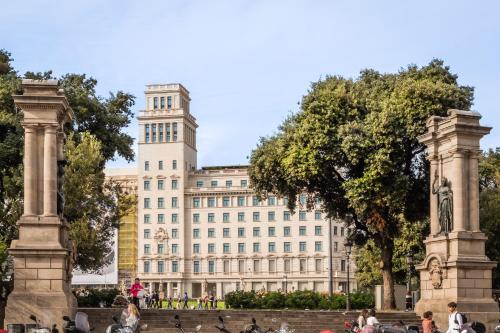 a large white building with people walking in front of it at 45 Times Barcelona Hotel in Barcelona