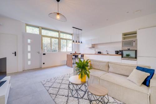 un salon et une cuisine avec un canapé et une table dans l'établissement La Petite Echoppe - Lumineux appt pour 4, à Bordeaux