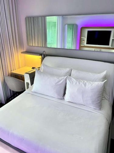 a white bed with white pillows in a room at YOTEL Boston in Boston