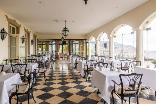 a dining room with white tables and chairs at Quinta Funchal Gardens - Adults Only in Funchal