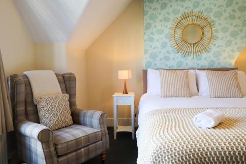 a bedroom with a bed and a chair and a mirror at The Albany Rooms Bexhill in Bexhill