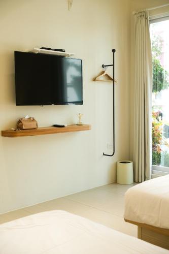 a bedroom with a flat screen tv on a wall at 蒔花澄旅 in Hengchun