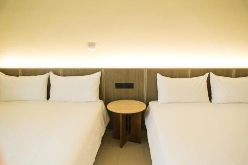 two beds in a room with a table between them at 蒔花澄旅 in Hengchun
