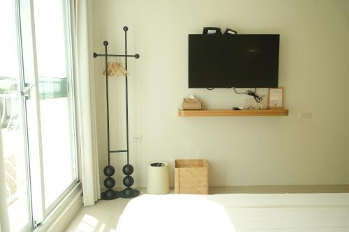 a bedroom with a bed and a tv on the wall at 蒔花澄旅 in Hengchun