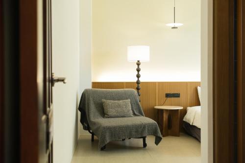 a room with a chair and a lamp and a bed at 蒔花澄旅 in Hengchun