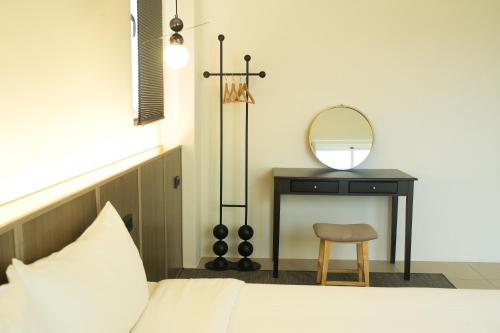 a bedroom with a bed and a table with a mirror at 蒔花澄旅 in Hengchun