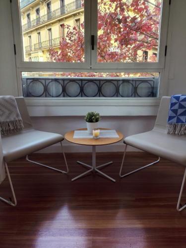 a room with two chairs and a table and a window at Pensión La Perla in Donostia-San Sebastián