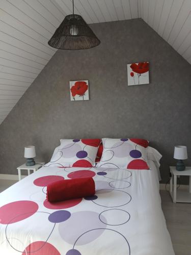 - une chambre dotée d'un grand lit avec des oreillers rouges et violets dans l'établissement Les hortensias de papy, à Plozévet