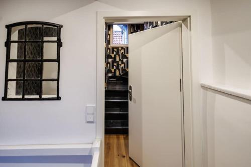 a hallway with a door leading to a stair case at Himmlisches Penthouse am Fischmarkt in Stade