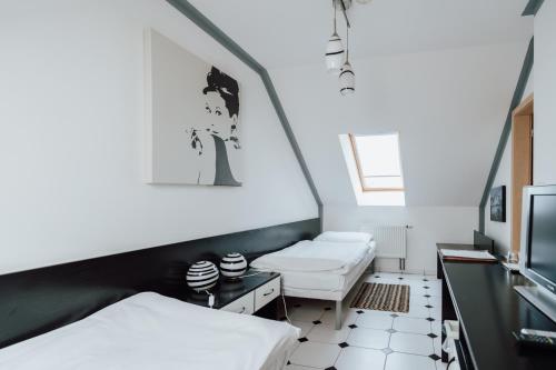 a room with two beds and a tv at Penzion Bene in Chotěboř