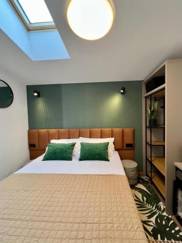 a bedroom with a large bed with green pillows at JADE - guesthouse in Buzău