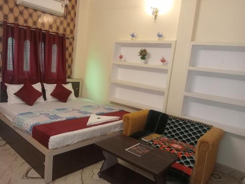 a bedroom with a bed and a table and a chair at Rudra Guest House in Rāmnagar