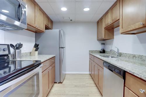 a kitchen with wooden cabinets and a refrigerator at Spacious and Minimalist Apartment on Pentagon City in Arlington