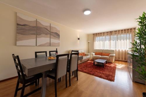 a living room with a dining room table and a couch at Maia's Cozy Apartment in Águas Santas