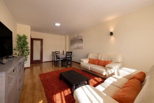 a living room with a white couch and a table at Maia's Cozy Apartment in Águas Santas