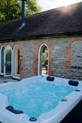 a hot tub in front of a brick building at The Hornbill at Home Farm Shropshire in Shrewsbury