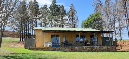 a small yellow house with a stone wall at Schaefers' Halt in Dullstroom