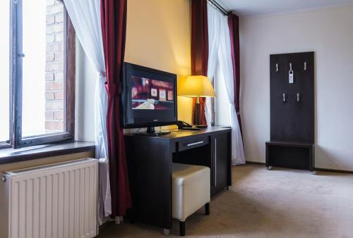 a room with a desk with a television on it at Zamek Gniew - Pałac Marysieńki in Gniew