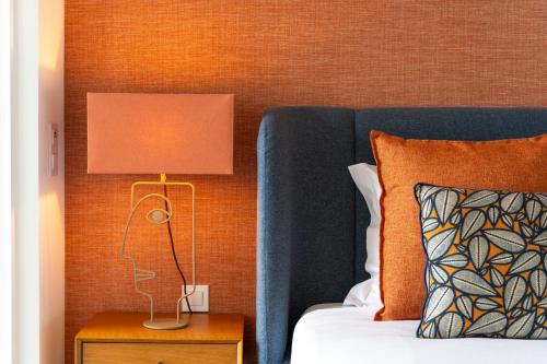 a lamp on a night stand next to a bed at Mar a Vista - Condominium with Pool, Gym and Sea Views in Nazaré