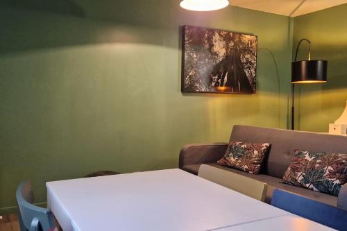 a living room with a couch and a table at Charmant appartement au calme, proche centre in Aire-sur-lʼAdour