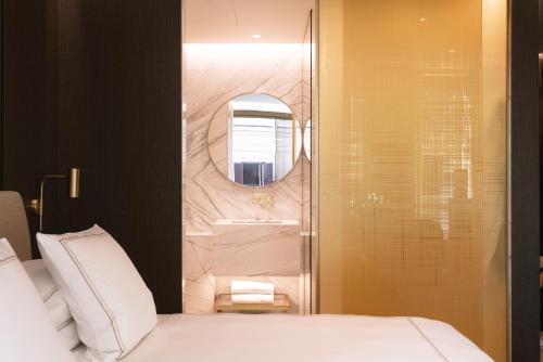 a bathroom with a bed and a mirror and a sink at The First Musica - Preferred Hotels & Resorts in Rome