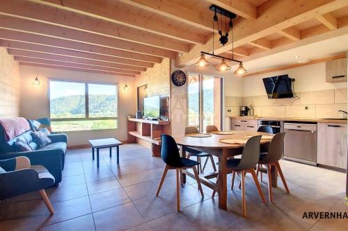 une cuisine et un salon avec une table et des chaises dans l'établissement Lona Spa, à Chambon-sur-Lac