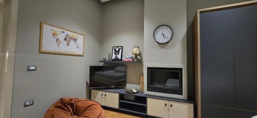sala de estar con TV y reloj en la pared en Girasole Home, en Tirana