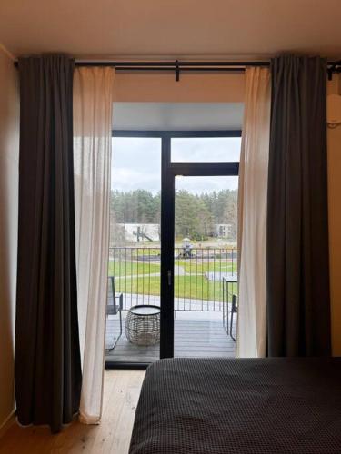 a bedroom with a door open to a screened in porch at Albatros Resort SPA in Ķesterciems