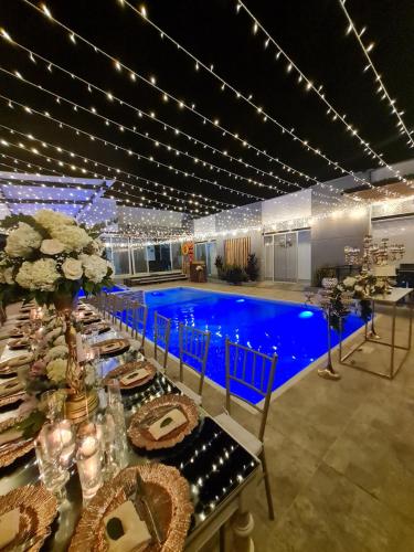 a dining room with a pool in the background at Villa Tokyo in Ibagué