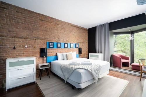 a bedroom with a bed and a brick wall at Two bedroom duplex in Plateau Mont-Royal district in Montréal