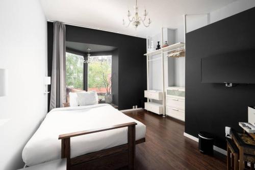 a bedroom with a white bed and a black wall at Two bedroom duplex in Plateau Mont-Royal district in Montréal
