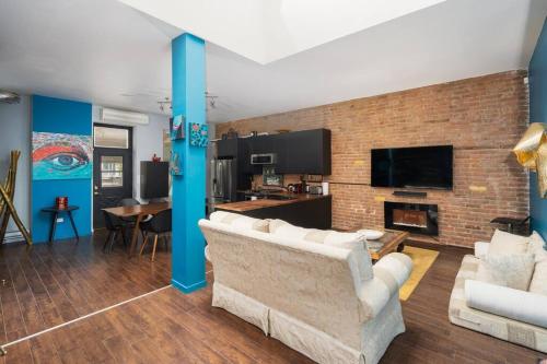 a living room with a couch and a brick wall at Two bedroom duplex in Plateau Mont-Royal district in Montréal