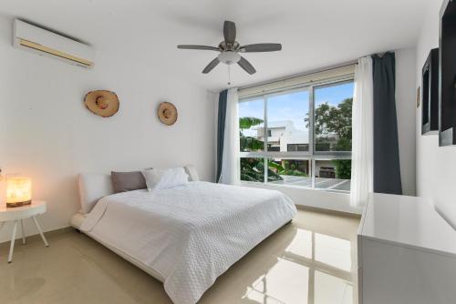 a white bedroom with a bed and a window at Casa Lula 5-BR Getaway in Riviera Maya in Playa del Carmen