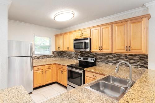 a kitchen with wooden cabinets and a stainless steel refrigerator at Westgate Blue Tree Resort in Orlando